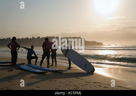 Un istruttore dà un inizio di mattina lezione a scuola di surf sulla spiaggia di Bondi Beach a Sydney Foto Stock