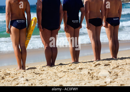 Membri del Bondi bagnanti Surf Life saving Club stand presso il pronto durante un corso di formazione per praticare l'iconica Bondi Beach Foto Stock