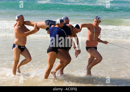 Lifesavers pratica un salvataggio di surf sulla spiaggia Bondi utilizzando la tradizionale linea di cintura e methond aspo Foto Stock