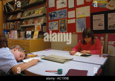 Ragazzo della scuola elementare addormentato in classe, testa esaurita sulla scrivania. Londra 1980s Regno Unito HOMER SYKES Foto Stock