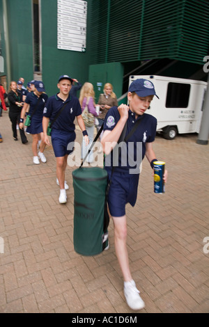 La linea della sfera ragazzi a piedi per una partita a tennis di Wimbledon campionati UK Foto Stock