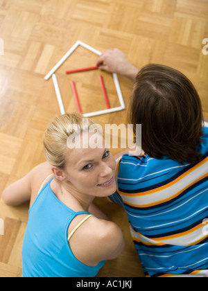 Giovane giacente sul piano, edificio house con penne Foto Stock