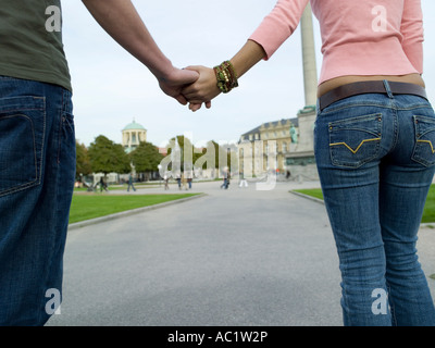Germania; Stoccarda, giovane camminando mano nella mano, biew posteriore Foto Stock