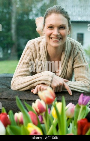 Donna sul divano guardando felice Foto Stock