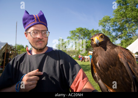 Un falco in appoggio su una falconer il braccio ad una festa del rinascimento nel Nebraska. Foto Stock