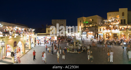 Un due foto panoramiche di cucitura sera vista notturna di turisti intorno alla fontana nella piazza Ippokratous a Rodi Città Vecchia. Foto Stock