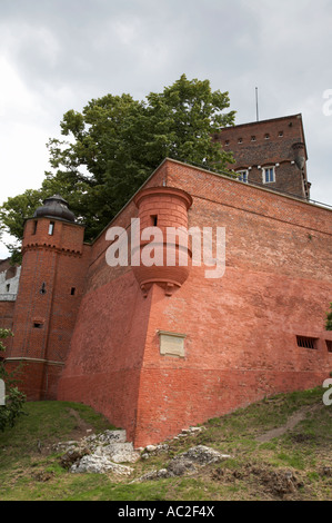 Mattone rosso alte mura difensive e la torretta con torre giù per dragons den dalla collina di Wawel e il castello di Cracovia Foto Stock