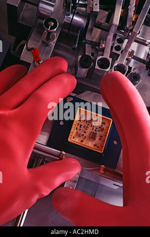Anche se si indossano guanti di assemblaggio del circuito elettronico in camera bianca Foto Stock