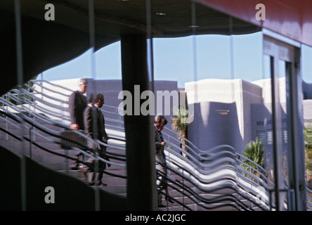 Imprenditori di discesa delle scale si riflette nel vetro edificio per uffici Foto Stock