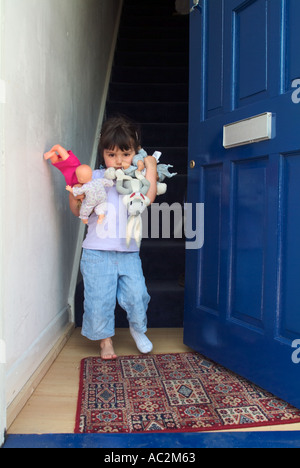 Bambino tenendo la bambola in piedi presso lo sportello anteriore,Londra,Inghilterra Foto Stock