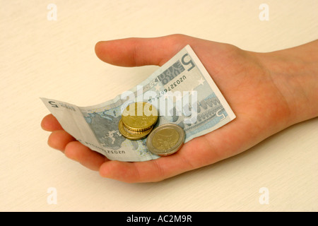 Un giovane ragazzo in mano azienda denaro Foto Stock