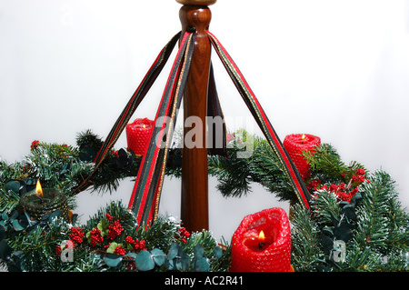 Corona di Avvento con quattro candele accese contro uno sfondo bianco Foto Stock