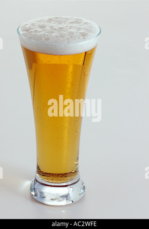 Bicchiere di birra con testa su sfondo bianco Foto Stock