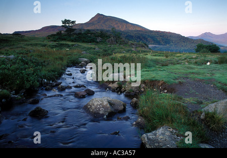 Sunrise over Moel Siabod montagna nel Parco Nazionale di Snowdonia nel Galles con un flusso in esecuzione verso di esso all'alba Foto Stock