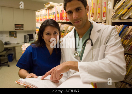 Ritratto di giovane medico e infermiere guardando sopra i grafici di medico Foto Stock