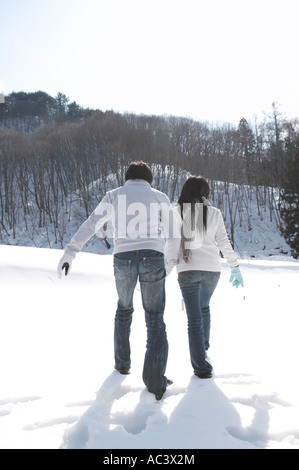 Coppia giovane a piedi nella neve Foto Stock