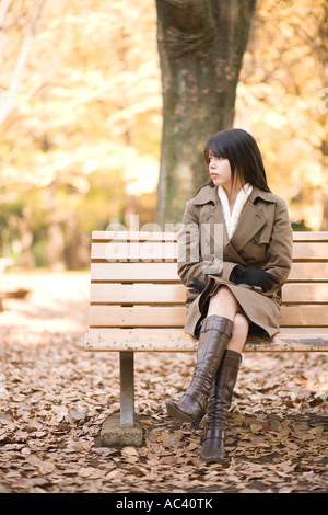 Giovane donna seduta sul banco di lavoro Foto Stock