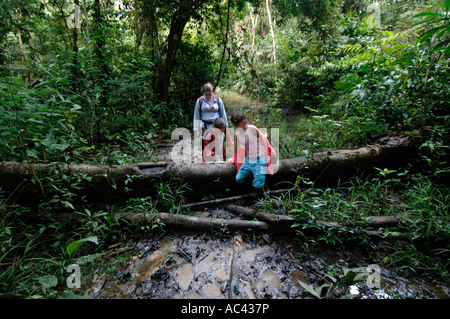 Il Perù avventura di vacanza American ragazze tromp attraverso il fango sul sentiero della foresta pluviale in vacanza a Tahuayo Lodge Foto Stock