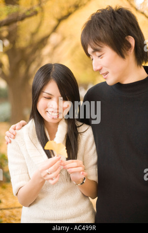 Coppia giovane guardando giallo foglie di ginkgo Foto Stock