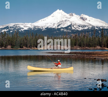 La pesca a mosca da una canoa al Lago di scintille con rotte Top Mountain in background in Oregon centrale Foto Stock