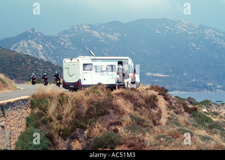 Strada costiera da Ajaccio vicino alle isole Sanguinaires con camper viaggiatori in piedi fuori e paesaggio collinare oltre Ajaccio Corsica Francia Foto Stock