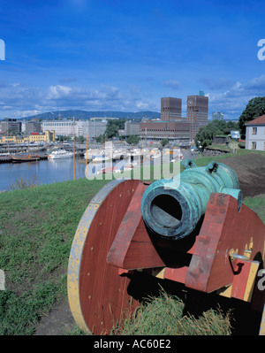 Il vecchio mortaio in bronzo nella pistola di legno carrello con Oslo Rådhus (Municipio) e il porto al di là, da La Fortezza di Akershus, Oslo, Norvegia. Foto Stock