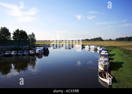 Barche ormeggiate dalle rive del fiume Ant sulla Norfolk Broads a valle del Ludham Bridge, Ludham, Norfolk, Inghilterra, Regno Unito. Foto Stock