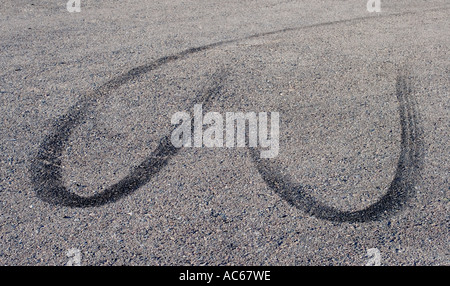 Cuore nero skidmarks sagomata su GRIGIO ASFALTO Foto Stock