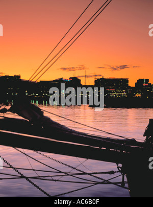 Arancio brillante tramonto dietro Aker Brygge, visto oltre il porto di Oslo, Oslo, Norvegia. Foto Stock