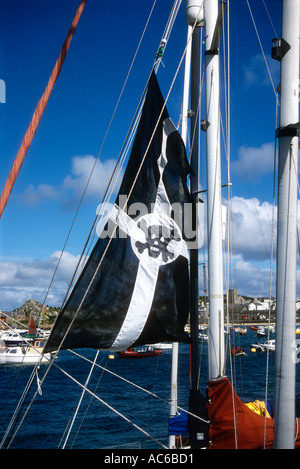 Una barca battente bandiera della Cornovaglia rovinato con un stile pirata Teschio e Ossa Croce a Hugh Town quay St Marys Isole Scilly E Foto Stock