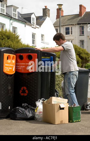 L'uomo impiegato dalle autorità locali lo svuotamento di cassonetti per il riciclaggio di bottiglie di vetro, le bottiglie di plastica lattine di bevande e giornali, Aberystwyth Foto Stock