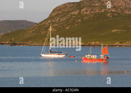 Piccolo yacht e barche da pesca ormeggiate nella baia orientale dell'istmo su Vatersay, Ebridi Esterne Foto Stock