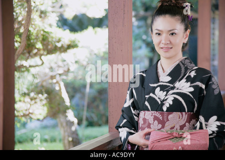 Giovane donna in kimono azienda dono avvolto Foto Stock