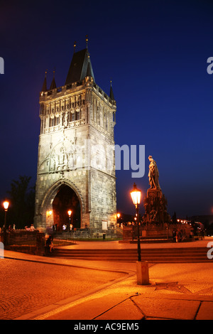 Vista notturna della Torre illuminata del Ponte della città Vecchia di Praga con statue e lampioni su un cielo blu profondo. Foto Stock