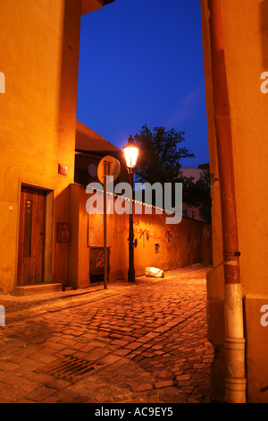 Vicolo acciottolato illuminato con lampione e graffiti a Praga di notte. ZA Hastalem Street, Praga Foto Stock