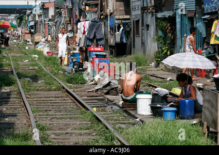 Occupanti abusivi lungo i binari ferroviari a Manila Foto Stock