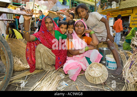 Un gruppo familiare di donne e bambini posano per una fotografia al colorato mercato nel centro di Udaipur. Foto Stock