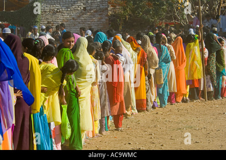 Una lunga coda di donne e ragazze vestiti nei loro vestiti migliori aspettando pazientemente che il cibo gratuito presso il festival di Mewar. Foto Stock