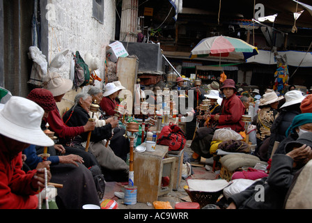 Riuniamo i pellegrini buddisti in meditazione con ruote della preghiera di Jokhang Lhasa Tibet Cina Foto Stock