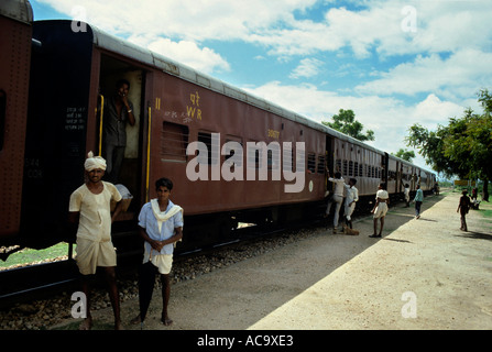 India due uomini stavano in piedi fino in prossimità di un treno fermo in una stazione ferroviaria Tra Bombay e Udaipur Foto Stock