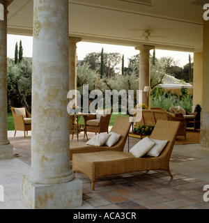 Sedie a sdraio sulla veranda colonnata in spagnolo villa Foto Stock