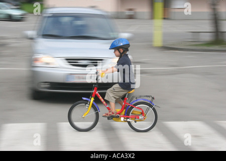 Bambino con una bicicletta su attraversamento pedonale Foto Stock