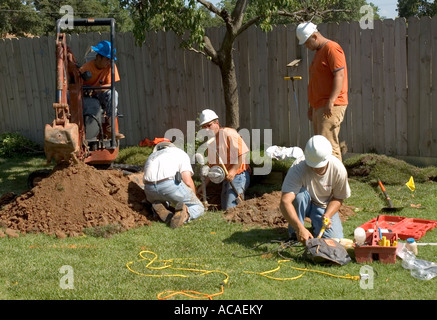 Equipaggio di costruzione sostituzione contatore di gas e la linea con uso di mini-via retroescavatore. Oklahoma City, Oklahoma, Stati Uniti d'America. Foto Stock