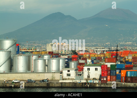 Napoli paesaggio industriale portuale contenitori stoccaggio serbatoi e gru oltre la nascita di spedizione vuota con persone che pescano dal molo accanto auto parcheggiate Foto Stock