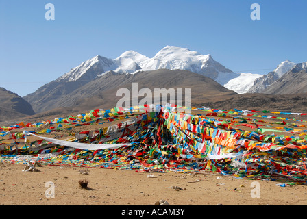 Colorati bandiere di preghiera wave sotto ghiaccio-capped Nyenchen Tanglha (7162 m) del Tibet la Cina Foto Stock