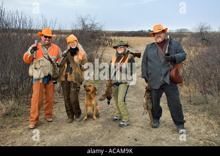 Due coppie in posa con il cane Fucili a canna liscia e fagiano durante Upland Bird Hunt vicino Tipton Kansas Foto Stock