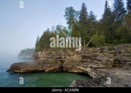 Scogliere rocciose e si avvicina al mattina nebbia sul Lago Michigan Grotta Punto Parcheggio contea Door County Wisconsin Foto Stock