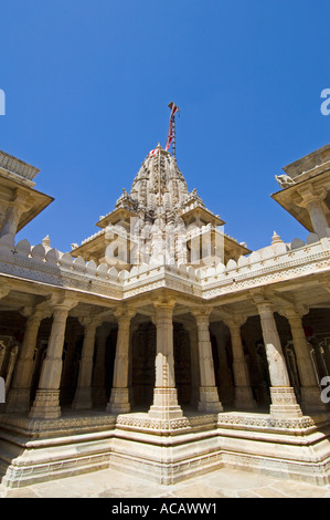 Vista esterna del intricate sculture di pilastri e una delle guglie a Adinatha tempio Jain contro un cielo blu chiaro. Foto Stock
