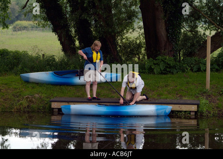 Uomo di mezza età e la donna launchong canoa Foto Stock