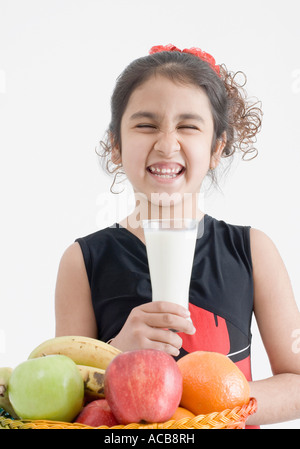 Ragazza con un bicchiere di latte e facendo una faccia Foto Stock